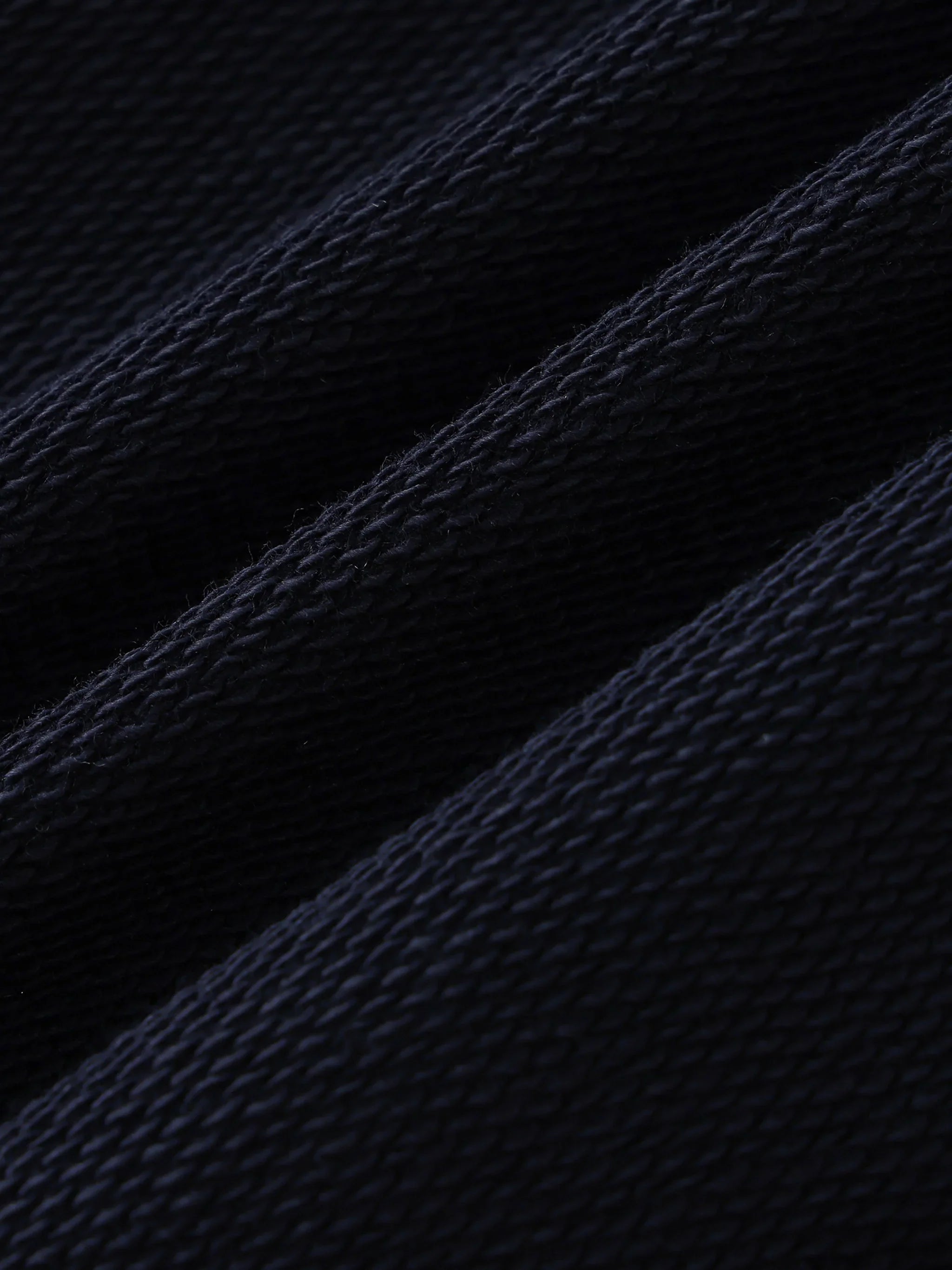 Close-up of heavyweight black textured fabric, showing thick weave and soft material