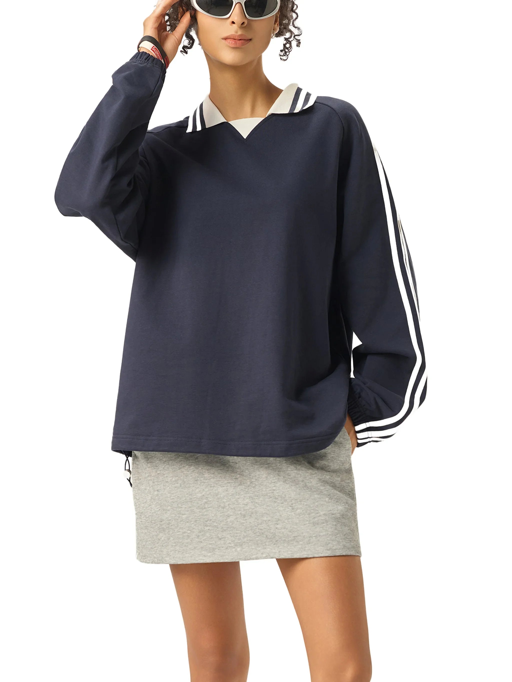 Woman in navy blue oversized pullover with striped collar and sleeves, gray mini skirt