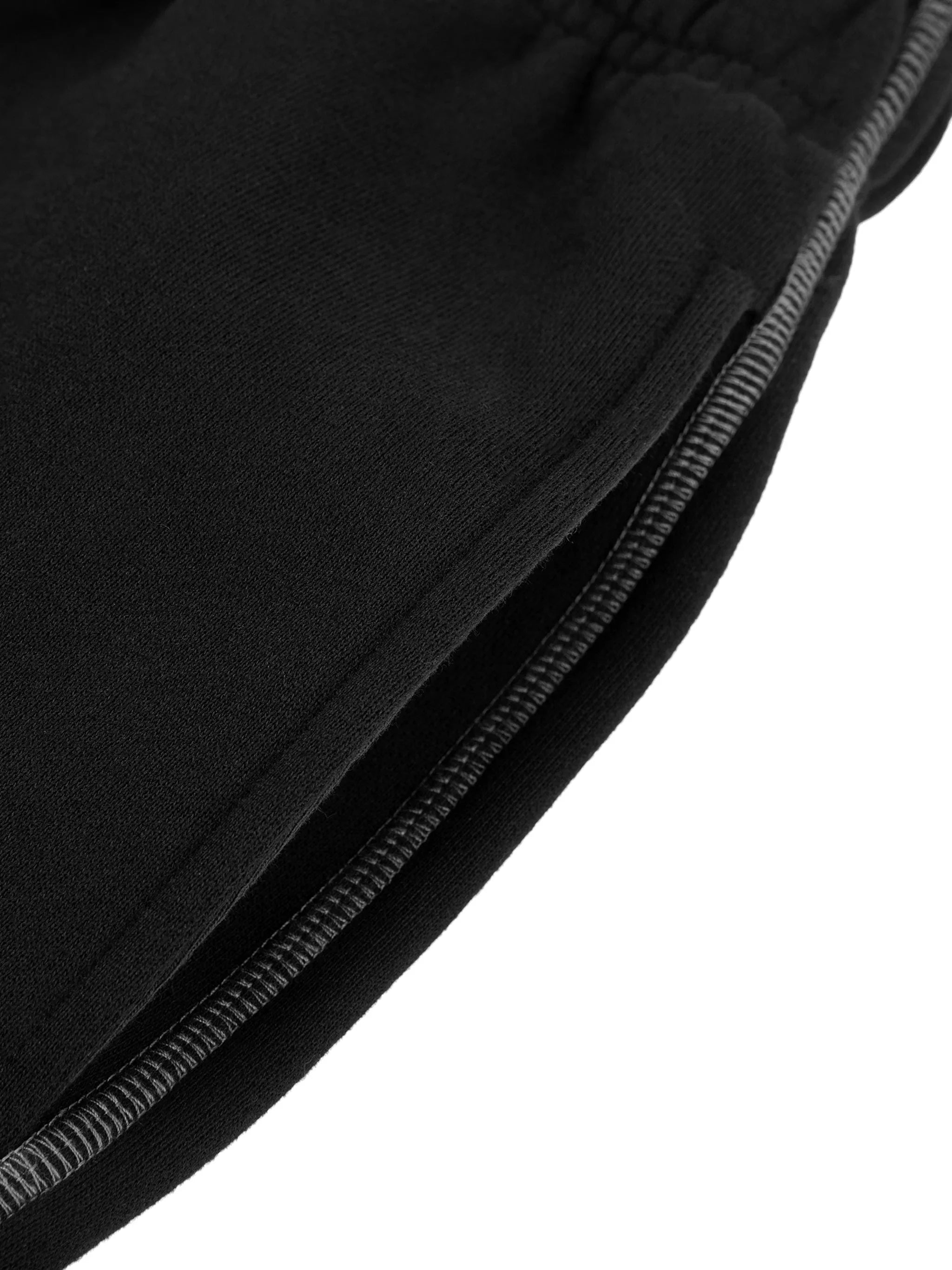 Close-up of black heavyweight streetwear fabric with visible stitching and elastic cuff detail.