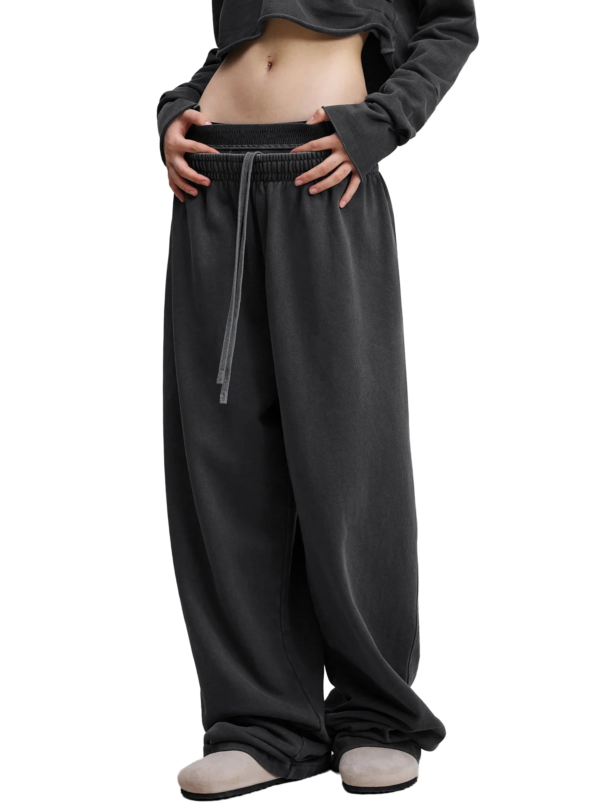 Woman wearing black oversized streetwear sweatpants with drawstring waist and casual top