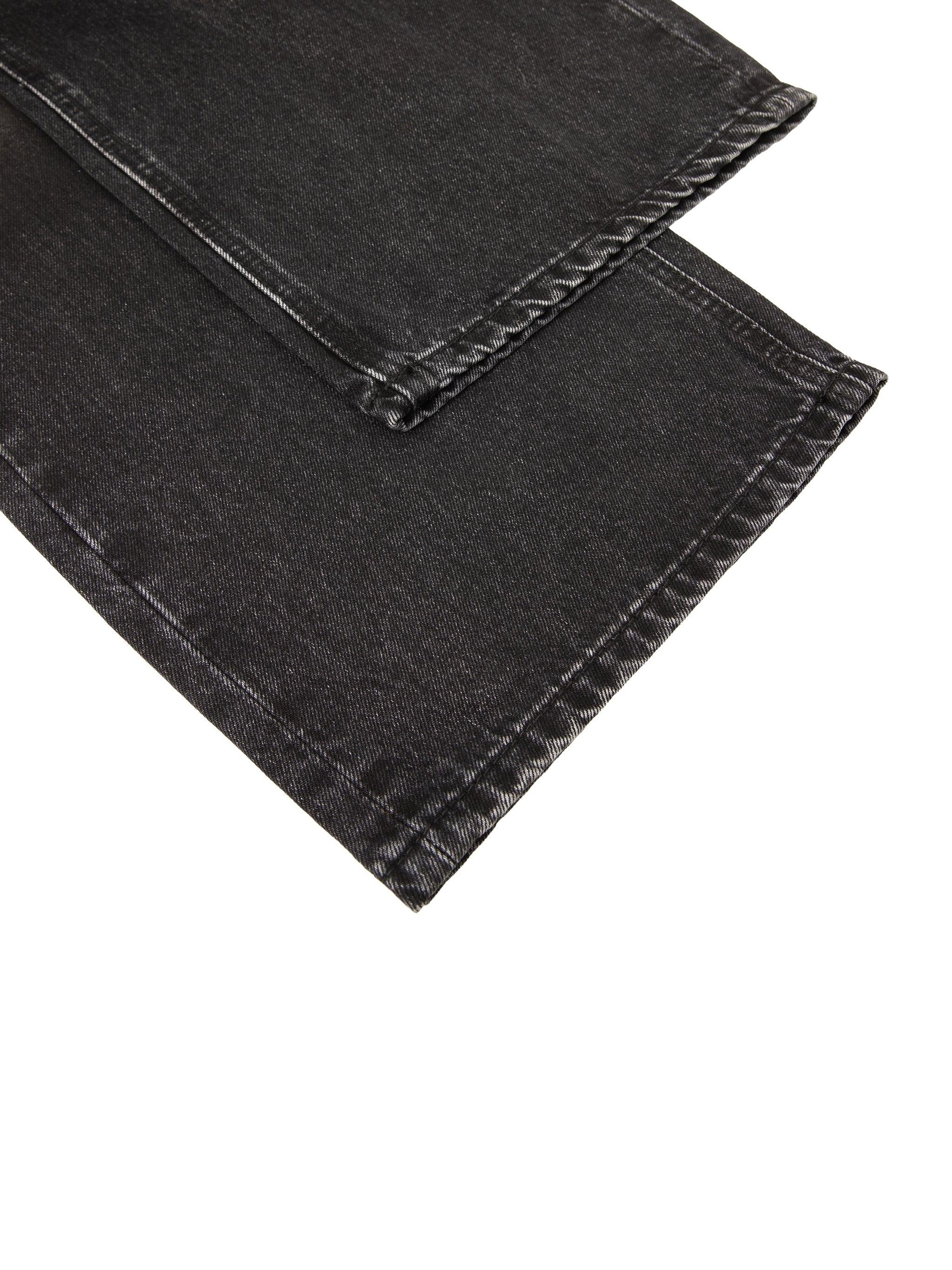 Close-up of black vintage wash denim jeans hem with visible stitching detail