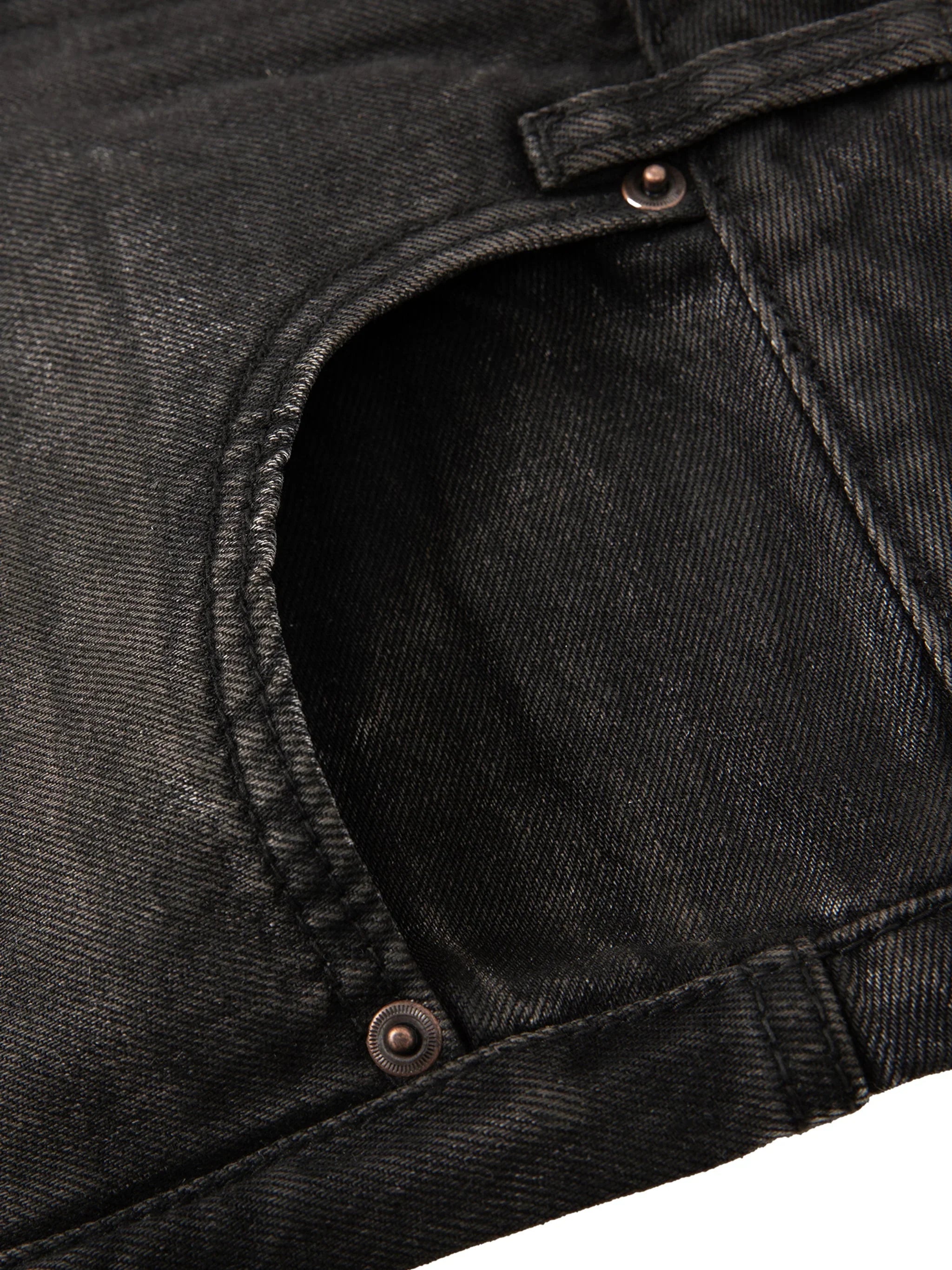 Close-up of black denim jeans front pocket and stitching details