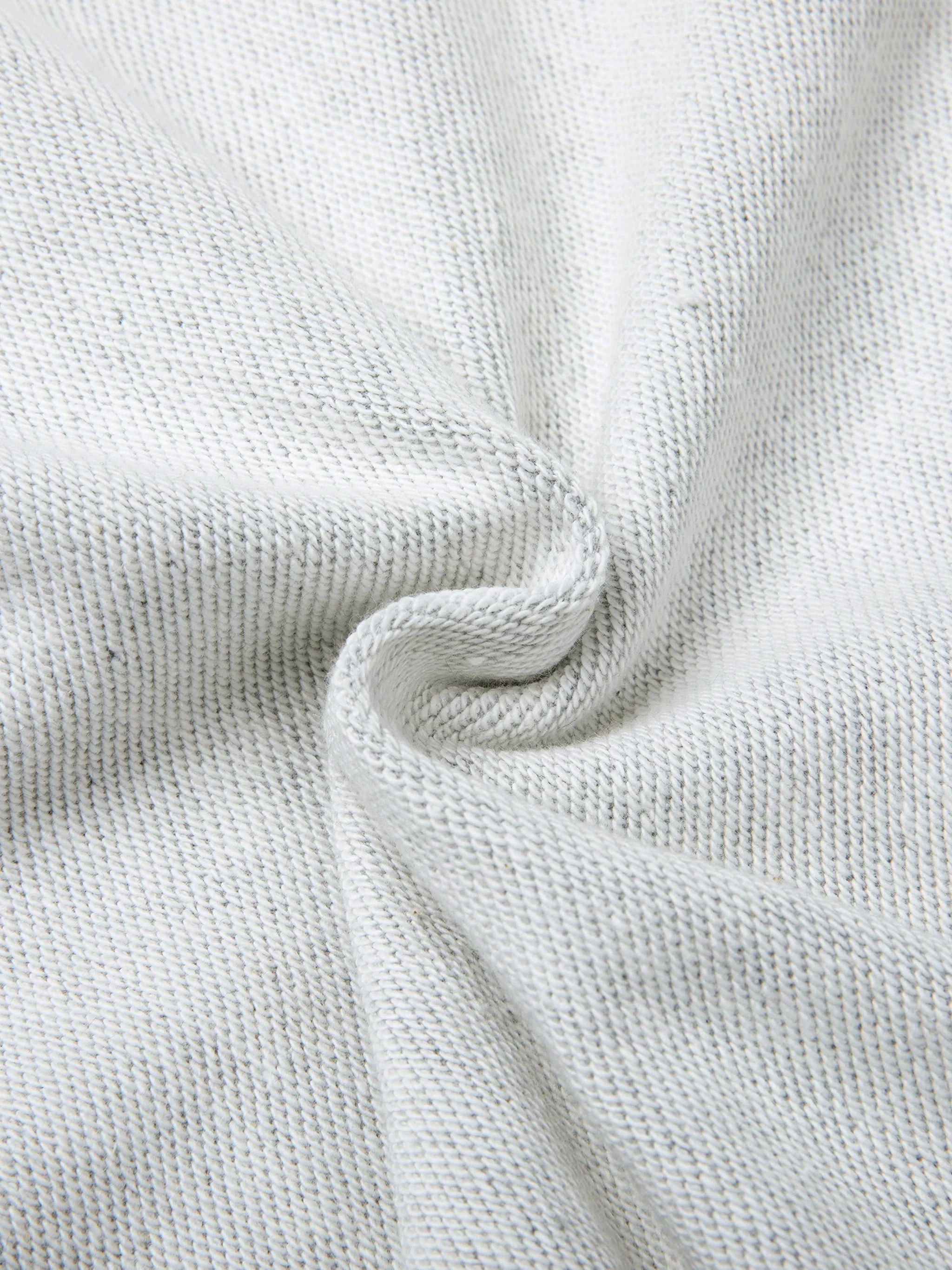 Close-up of heavyweight white knit fabric with visible texture and natural folds